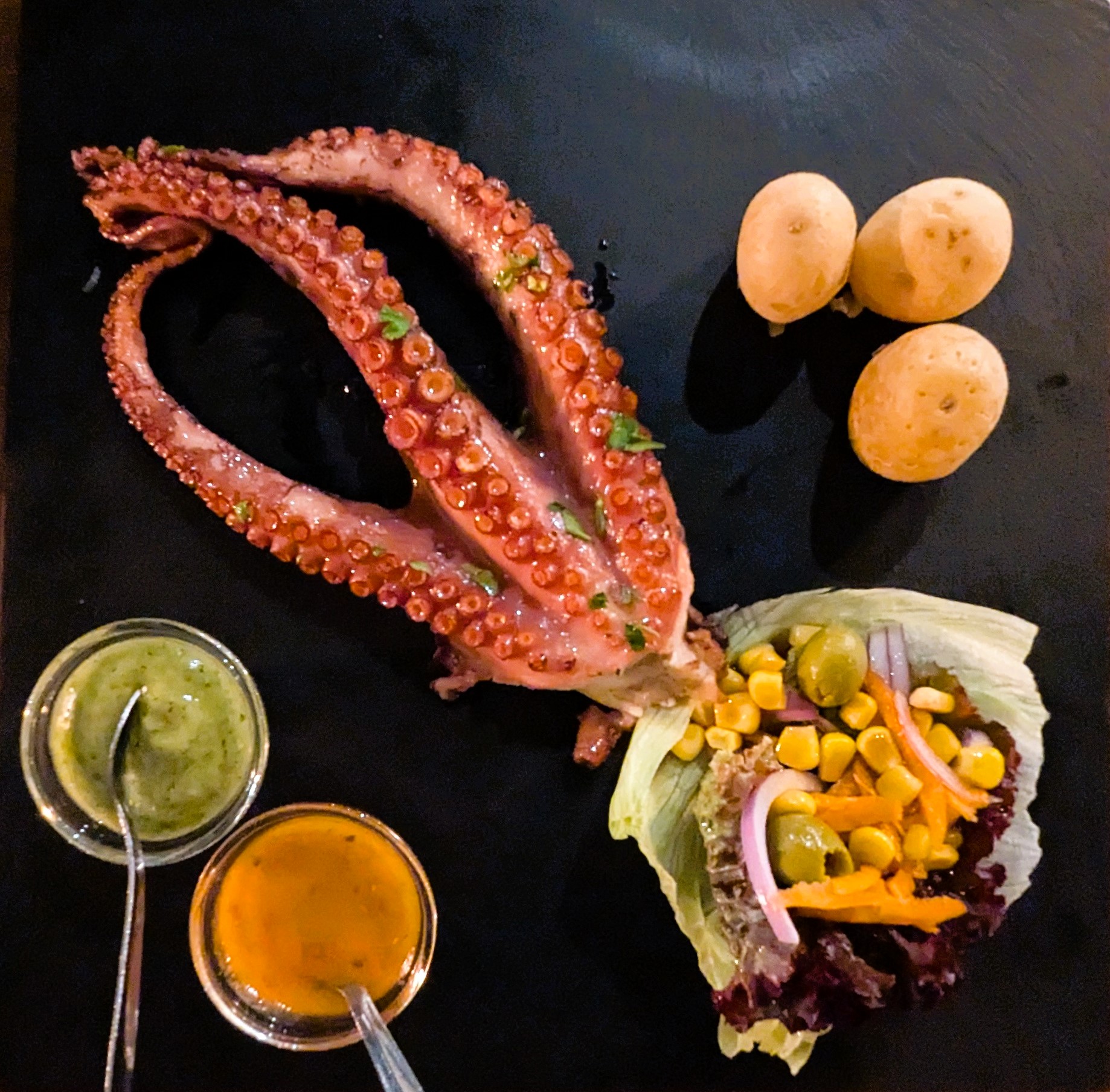 Foto von Oktopus mit Kartoffeln und Saucen
